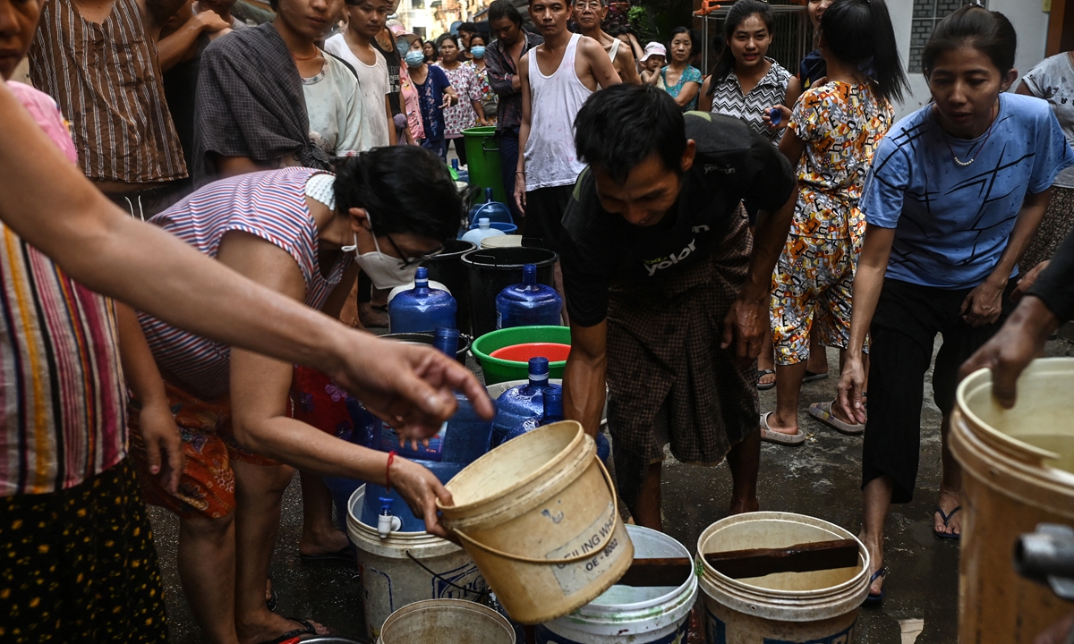 People fall in line to fill containers with water in Yangon, Myanmar on March 14, 2022, as thousands faced a water shortage due to power outages in the city. Photo: AFP